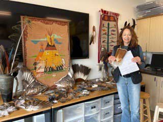 Woman standing next to native american cultural display